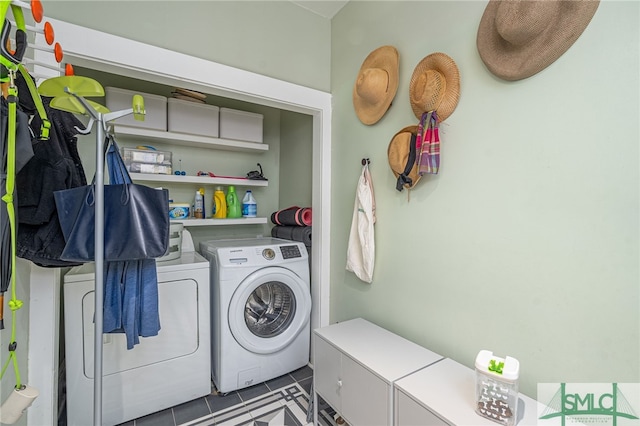 washroom with washing machine and dryer and dark tile patterned floors