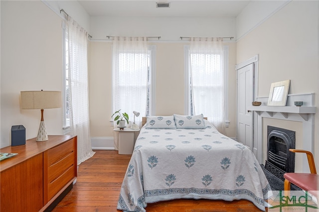 bedroom with a fireplace and wood-type flooring