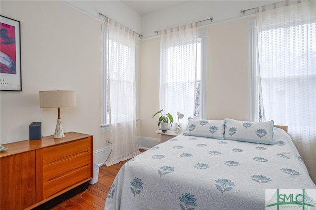 524 E Henry St, Savannah, GA 31401 - bedroom featuring multiple windows, dark wood-style floors, and baseboards