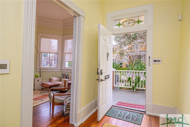 foyer entrance with hardwood / wood-style flooring and ornamental molding