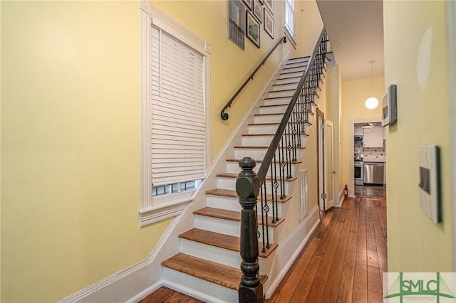 524 E Henry St, Savannah, GA 31401 - stairway with wood-type flooring, a high ceiling, and baseboards