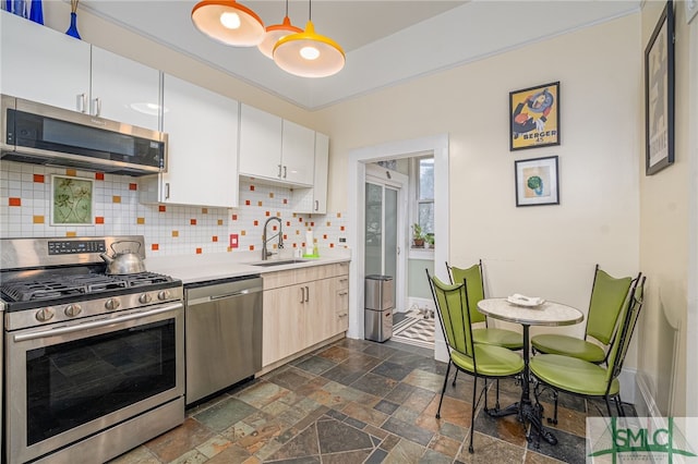 524 E Henry St, Savannah, GA 31401 - kitchen with stainless steel appliances, a sink, stone tile floors, backsplash, and light countertops