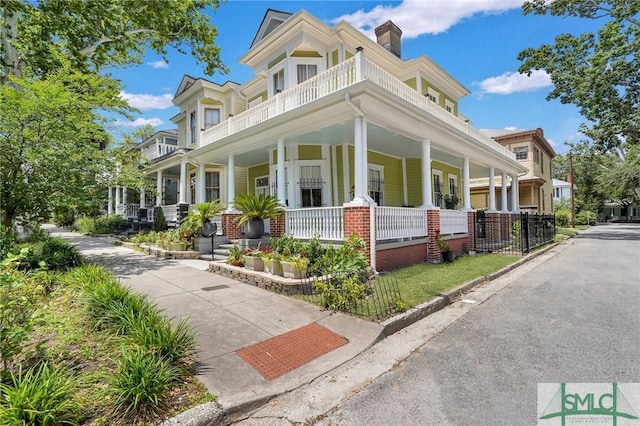 524 E Henry St, Savannah, GA 31401 - view of front of house with a balcony, covered porch, and a chimney