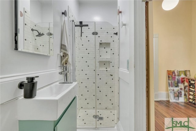 bathroom with hardwood / wood-style flooring and an enclosed shower