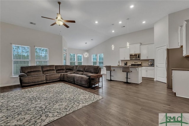 living room with ceiling fan, dark hardwood / wood-style floors, and high vaulted ceiling