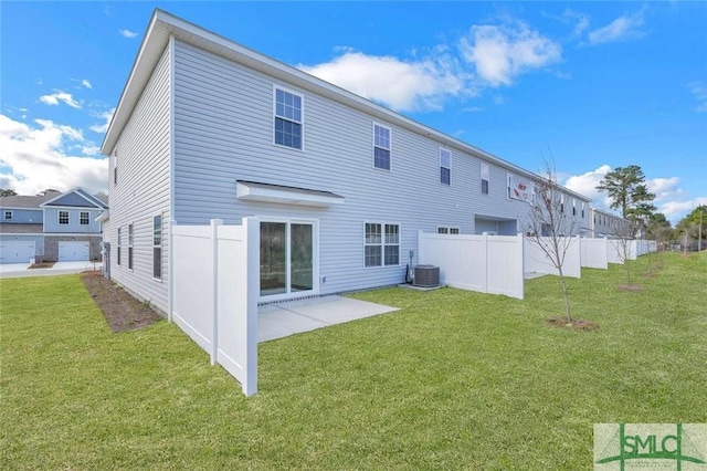 back of property with central AC, a patio area, and a lawn