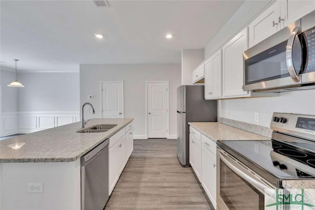 kitchen featuring pendant lighting, sink, white cabinets, a kitchen island with sink, and stainless steel appliances