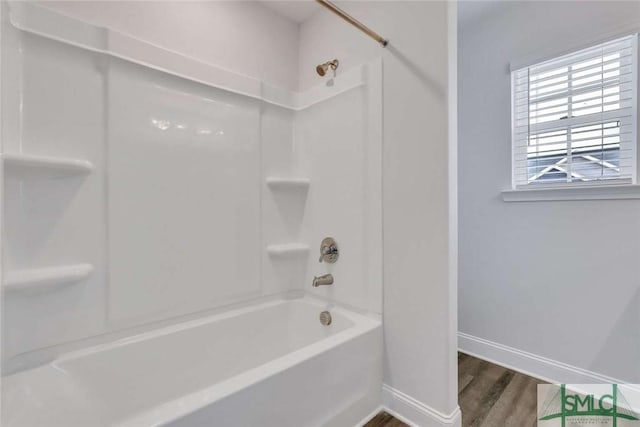 bathroom with hardwood / wood-style flooring and shower / bathtub combination