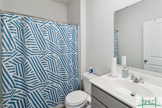 bathroom featuring walk in shower, vanity, and toilet