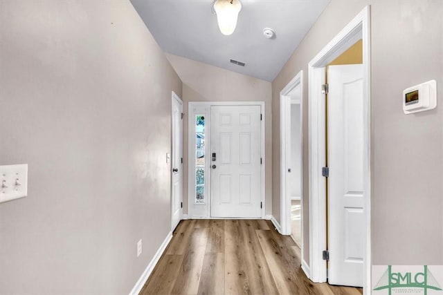 interior space with lofted ceiling and light hardwood / wood-style flooring