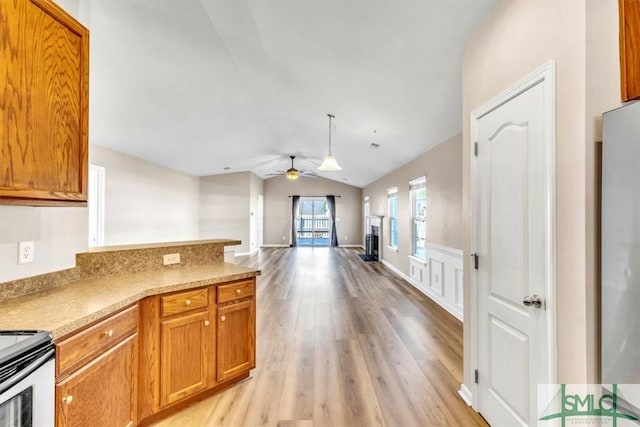 kitchen with lofted ceiling, light hardwood / wood-style flooring, ceiling fan, hanging light fixtures, and electric range