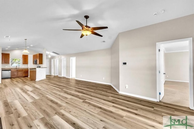 unfurnished living room with baseboards, light wood finished floors, lofted ceiling, a sink, and ceiling fan