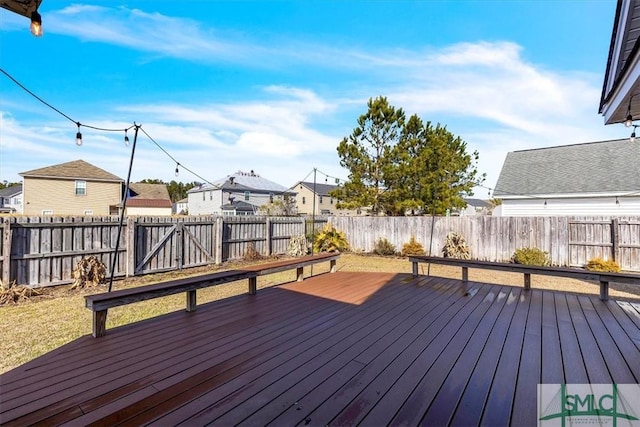 wooden deck featuring a residential view and a fenced backyard