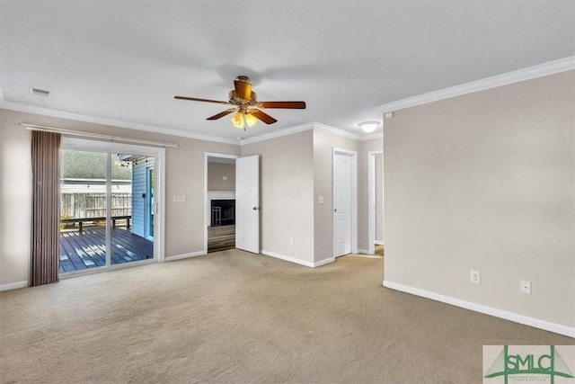 unfurnished room with carpet flooring, baseboards, crown molding, and a ceiling fan