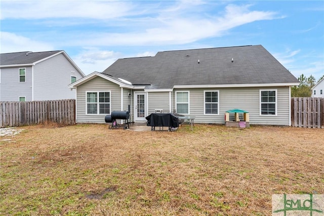 rear view of property with a yard and a patio area