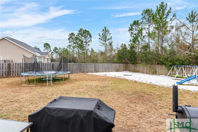 view of yard featuring a playground and a trampoline