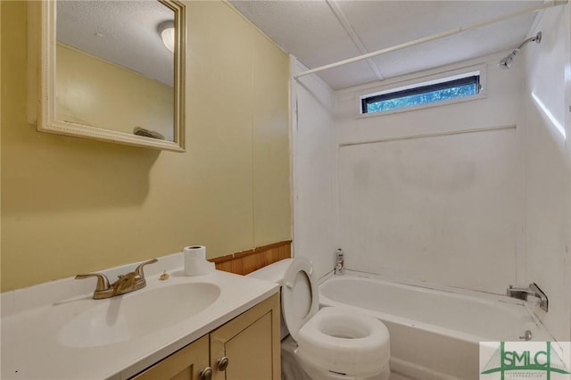 full bathroom featuring vanity, tub / shower combination, a textured ceiling, and toilet