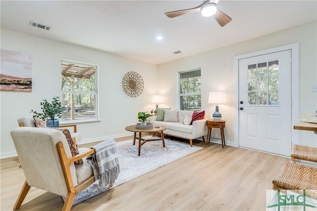 living room with plenty of natural light, ceiling fan, and light wood-type flooring