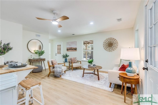 living room with ceiling fan and light wood-type flooring