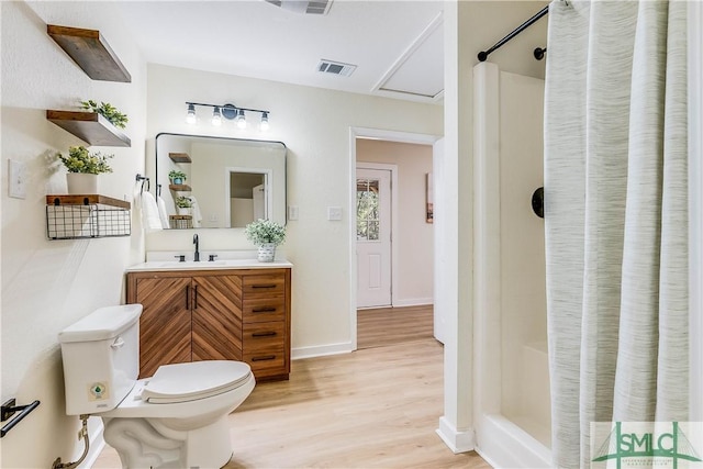 bathroom with hardwood / wood-style flooring, vanity, toilet, and a shower with curtain