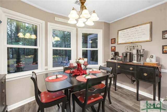 dining area with hardwood / wood-style flooring, crown molding, and a chandelier