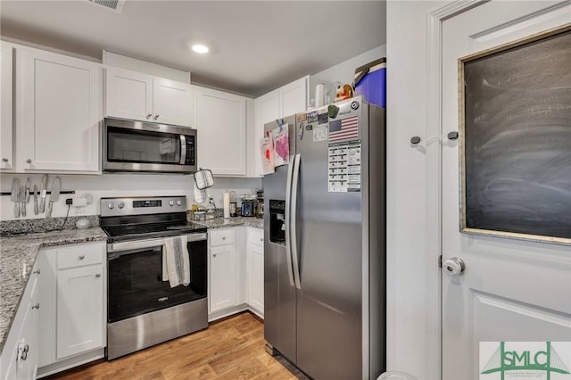 176 Coneflower Rd, Bloomingdale, GA 31302 - kitchen with light stone countertops, white cabinetry, and appliances with stainless steel finishes
