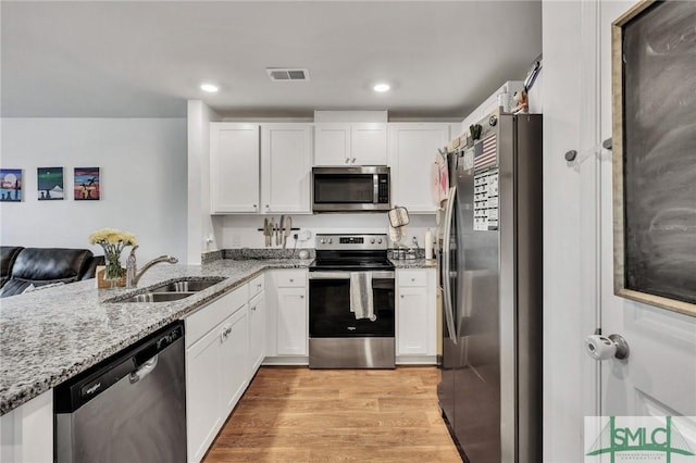 176 Coneflower Rd, Bloomingdale, GA 31302 - kitchen with stainless steel appliances, white cabinetry, light stone countertops, and sink