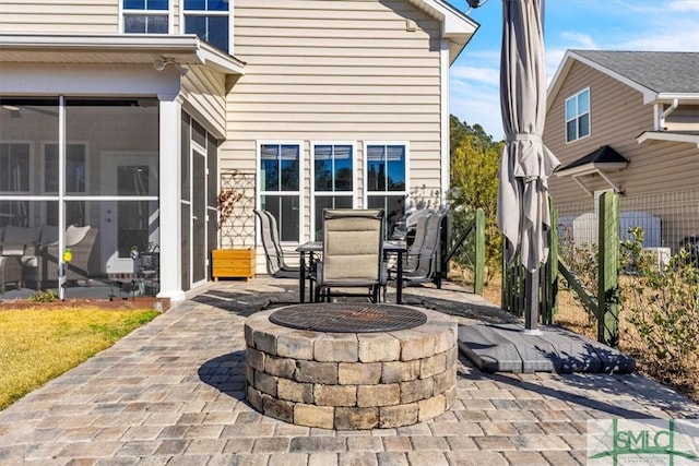 view of patio with a sunroom and an outdoor fire pit