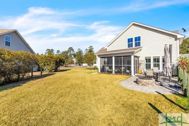 rear view of property with a patio, a sunroom, a yard, and an outdoor fire pit