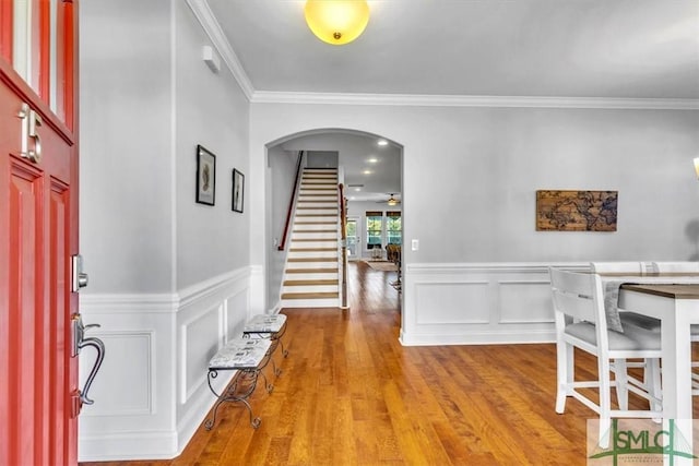 entrance foyer with crown molding, ceiling fan, and light wood-type flooring