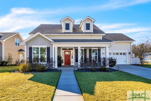 view of front of home with a garage, a front yard, and covered porch