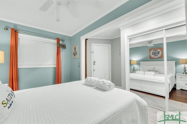 bedroom with a closet, crown molding, a ceiling fan, and wood finished floors