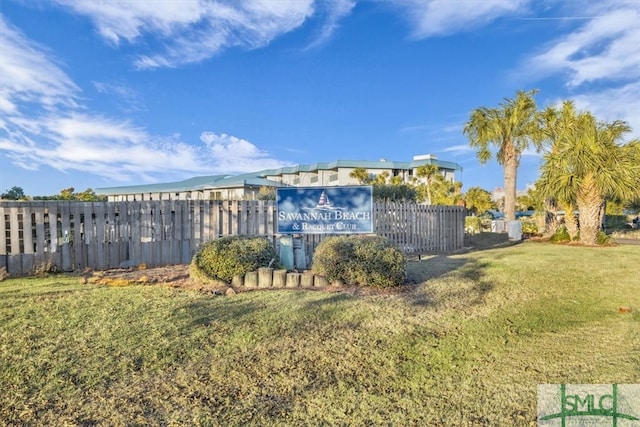community sign featuring fence and a lawn