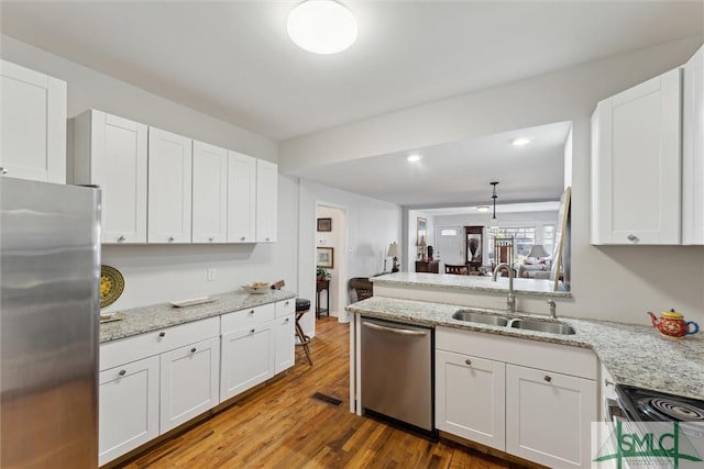 kitchen with sink, white cabinets, hardwood / wood-style flooring, hanging light fixtures, and stainless steel appliances