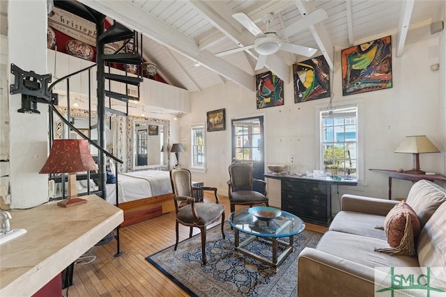 living room with ceiling fan, a healthy amount of sunlight, beam ceiling, and hardwood / wood-style floors