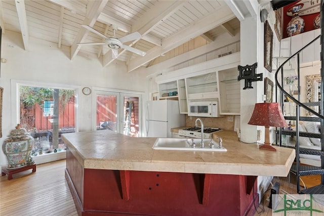 kitchen with beam ceiling, a breakfast bar area, white appliances, and french doors