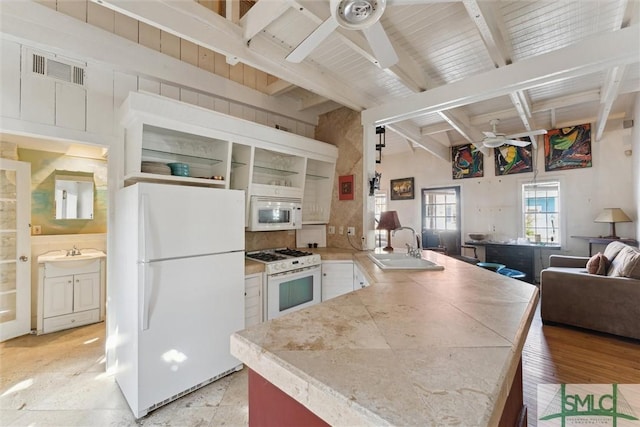 kitchen featuring sink, white appliances, ceiling fan, white cabinets, and beamed ceiling