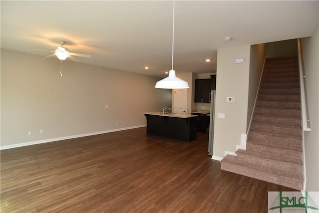 unfurnished living room with sink, dark hardwood / wood-style floors, and ceiling fan