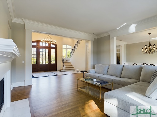 living room with crown molding, wood-type flooring, and a notable chandelier