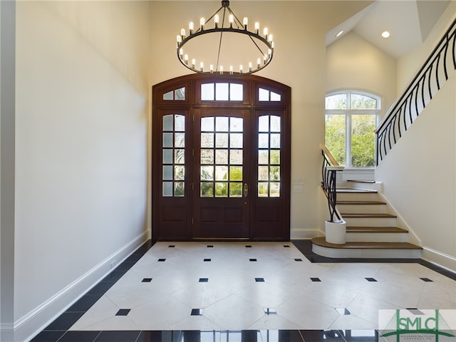 foyer with a chandelier, tile patterned flooring, and a high ceiling