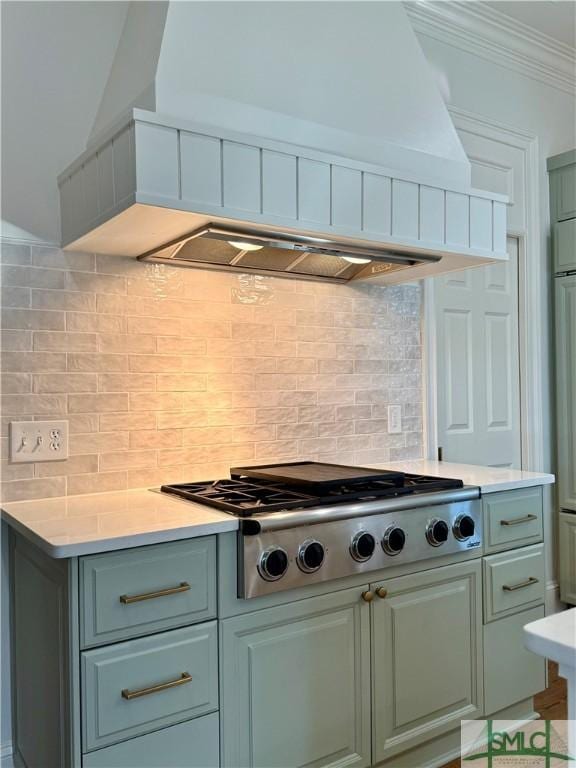 kitchen with custom exhaust hood, ornamental molding, stainless steel gas cooktop, and decorative backsplash