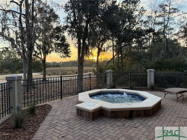 pool at dusk featuring a patio area