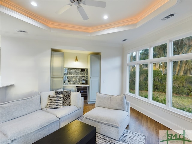 living room featuring wine cooler, plenty of natural light, a tray ceiling, and dark hardwood / wood-style flooring