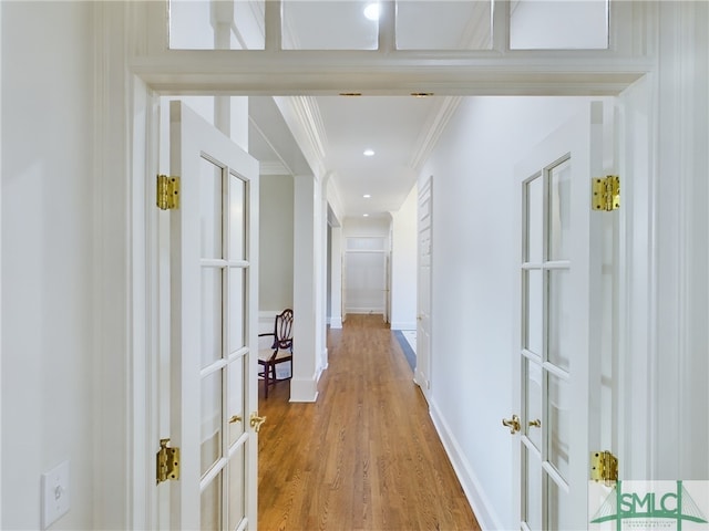 hall featuring french doors, ornamental molding, and hardwood / wood-style flooring