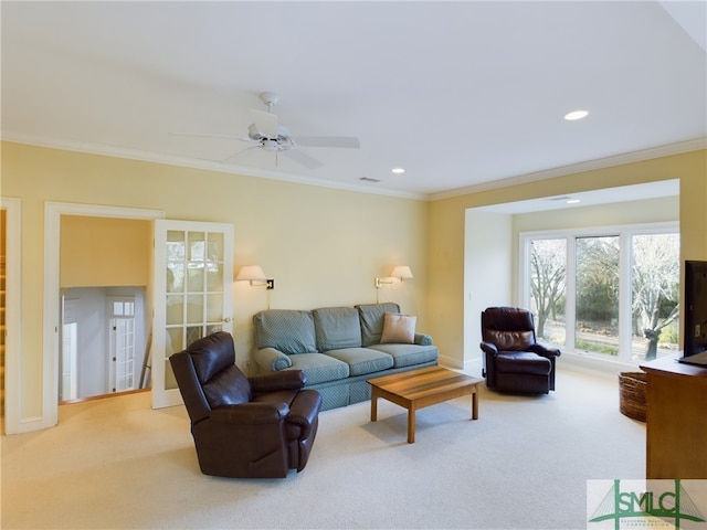 living room with crown molding, light colored carpet, and ceiling fan