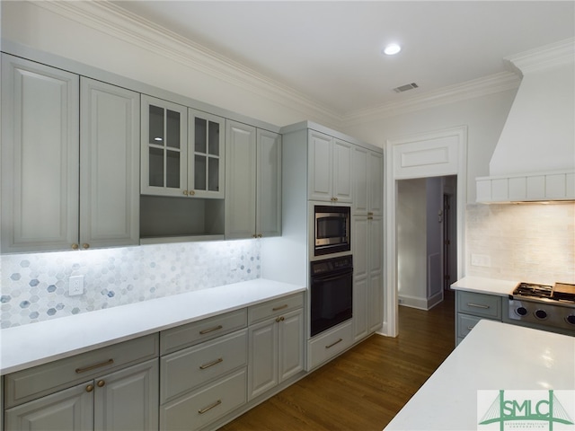 kitchen with gray cabinetry, crown molding, dark hardwood / wood-style floors, custom range hood, and stainless steel appliances