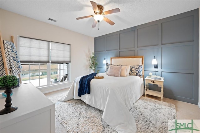 bedroom with ceiling fan and a textured ceiling