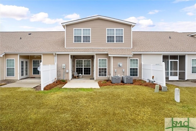 rear view of property with central AC unit, a patio area, and a lawn