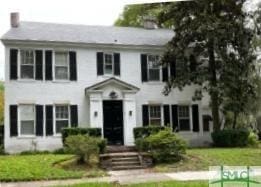 colonial inspired home with a front lawn