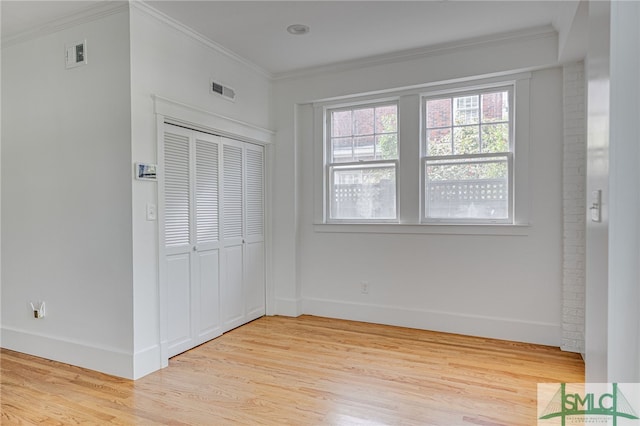 unfurnished bedroom with visible vents, crown molding, and light wood-style floors